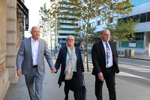Linda Reynolds (centre), with husband Robert Reid (left) and lawyer Martin Bennett (right).