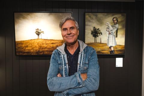 Christian Fletcher at his Dunsborough studio and gallery with his photo and a painting by Lauren Wilhelm. 