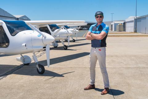 FlyOnE founder and chief executive Korum Ellis in front of three of the company's electric aircraft. Photo: FlyOnE.
