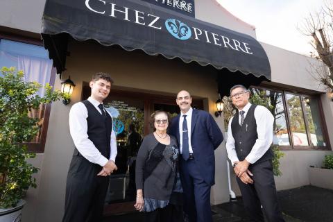Waitstaff Romain Delhelle (left) and Gede Sugiartha (right) with Pierre Ichallalene and his mother, Emily Ichallalene. Photo: Michael O’Brien