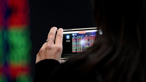 Person films ASX display board on mobile phone