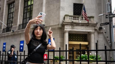 A women taking a selfie outside the stock exchange in New York