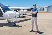 FlyOnE founder and chief executive Korum Ellis in front of three of the company's electric aircraft. Photo: FlyOnE.